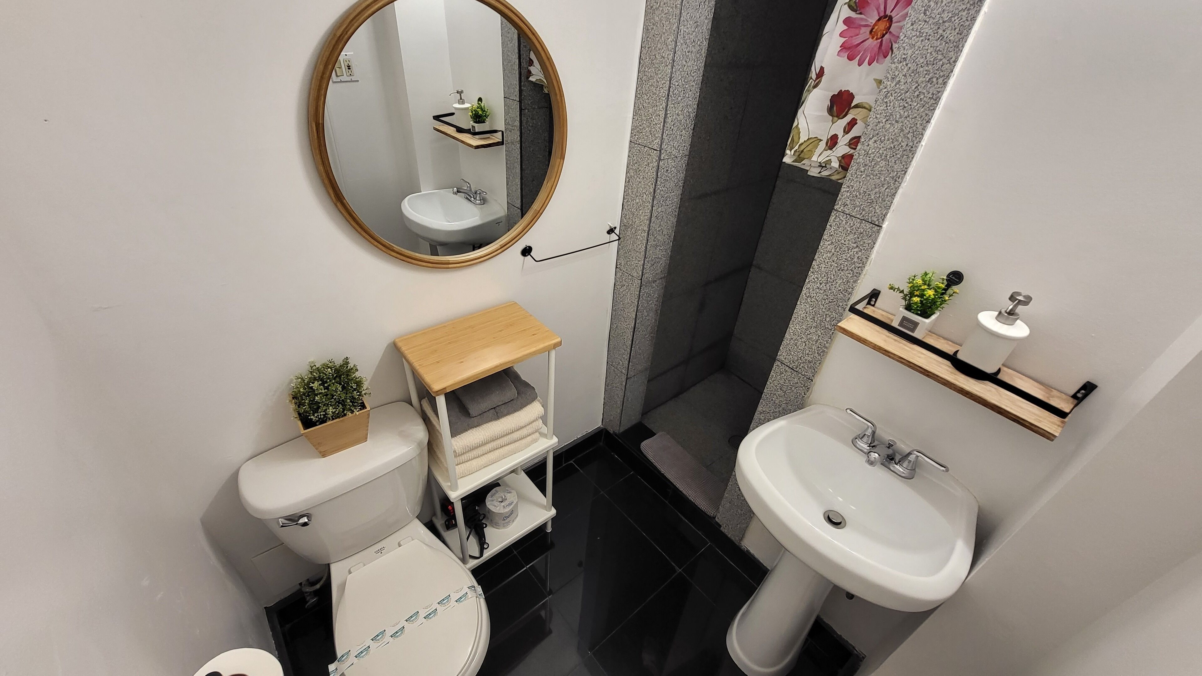 A compact bathroom with a toilet, sink, and a mirror.