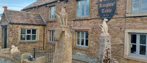 A traditional stone building with a sign reading "The Knights' Table."