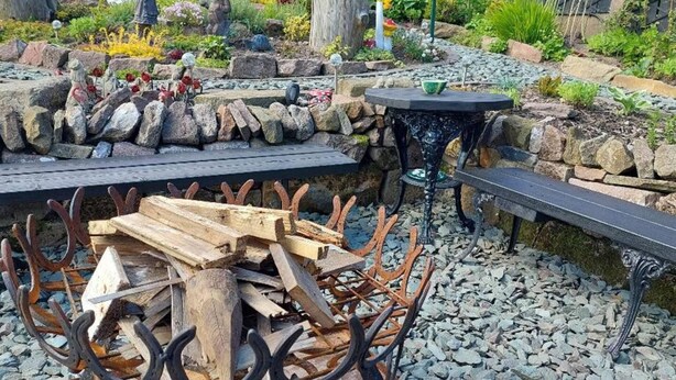 A garden with a stone wall, a wooden table, and a metal bench. - 2 Bed Flat - Sleeps 3 - Parking - Wifi (Buxton)