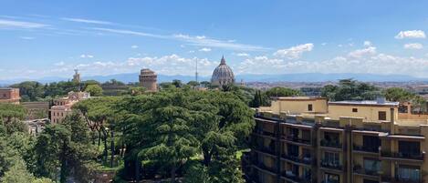 Zona residencial con edificios de varios pisos, abundante vegetación y una estructura con cúpula destacada al fondo.