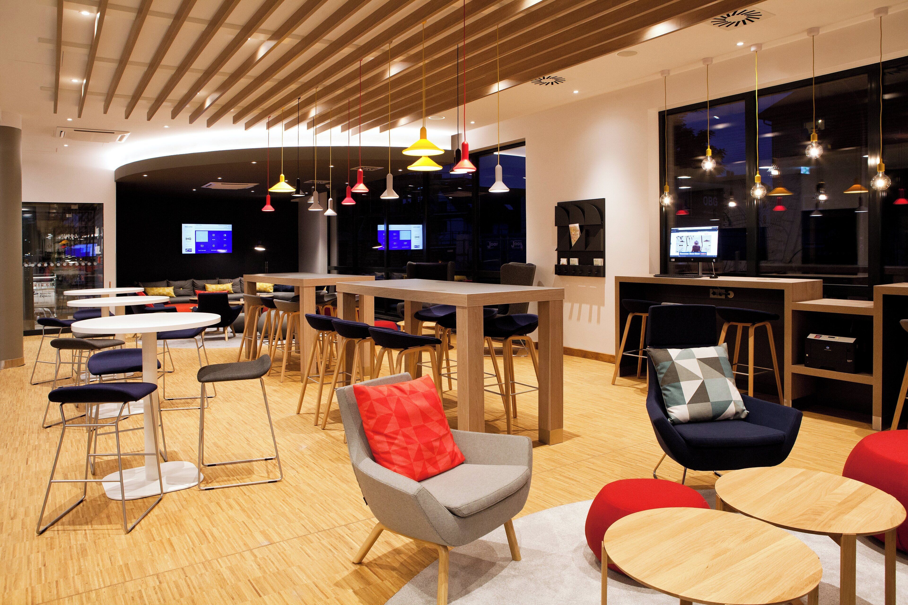 Un espace lounge moderne avec des sièges, des tables et un bar.