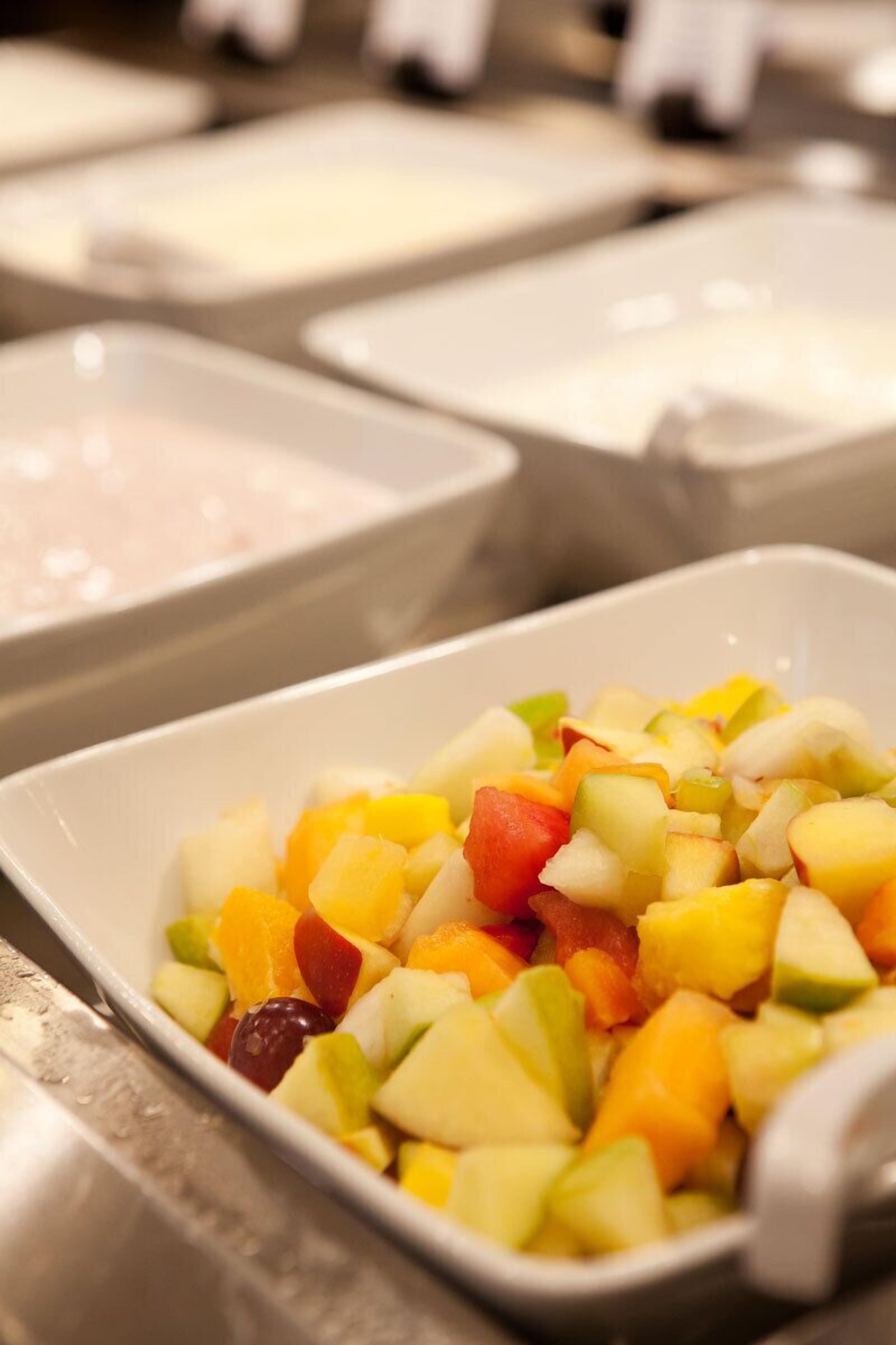A bowl of mixed fruit salad in a white bowl.