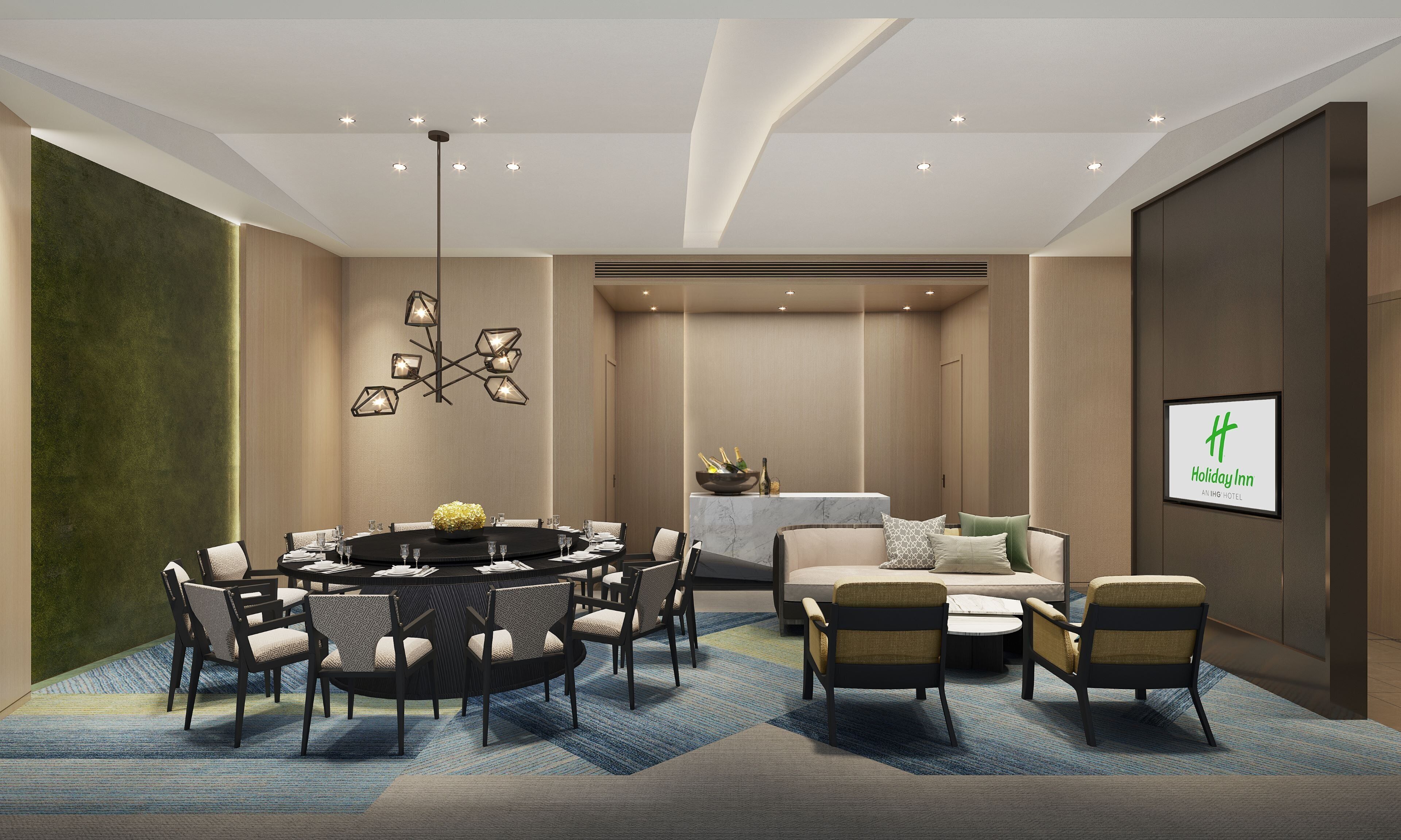 A modern hotel room with a round dining table, comfortable seating, a sofa, and a bed.