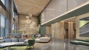 A spacious lobby with modern furniture, a high ceiling with hanging lights, and a large wall with a geometric design. - Holiday Inn YONGKANG by IHG (Jinhua)