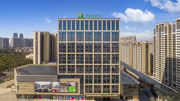 Welcome to the Holiday Inn, featuring a grid of windows and a flat roof.