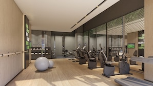 A modern gym with exercise equipment, a reception desk, and a large mirror. - Holiday Inn YONGKANG by IHG (Jinhua)