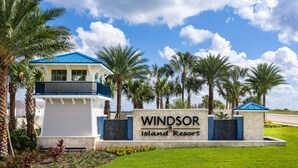 Naamplaatje voor Windsor Island Resort, met een modern gebouw en palmbomen.