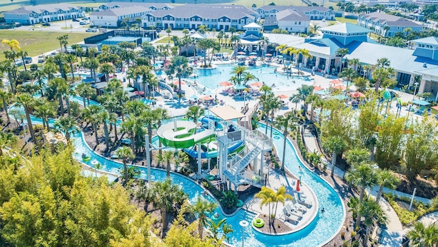Een resort met een groot centraal zwembad, meerdere waterglijbanen en diverse buitenzitplekken.