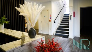 A reception area with a marble counter, a decorative vase, and a staircase. - Luxury Stevenage Town Centre Apartment (Stevenage)