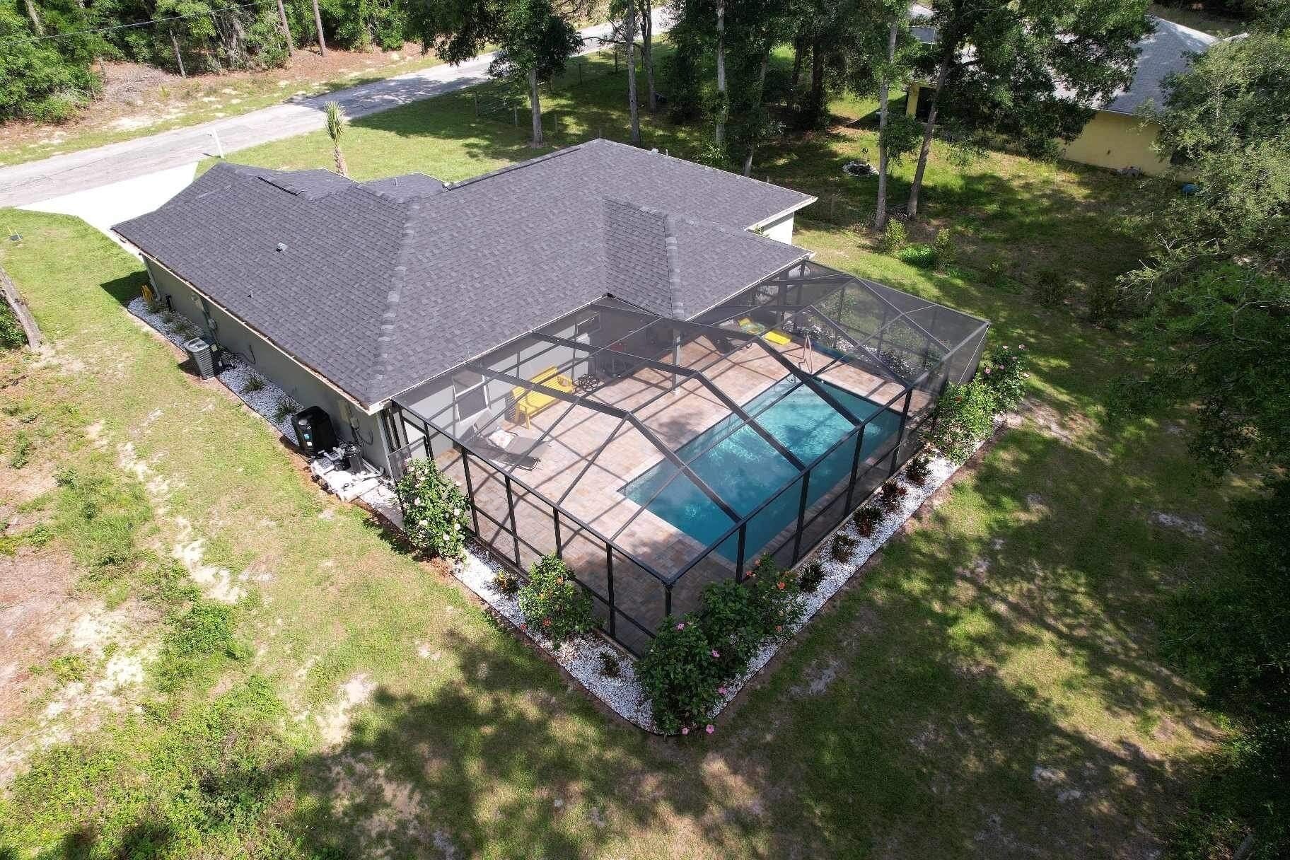 A house with a large screened-in porch and a swimming pool.