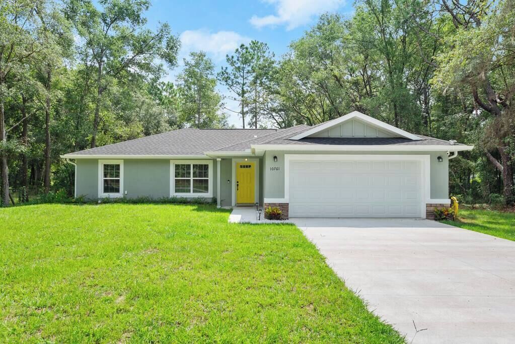 A single-story house with a garage, a front door, and a well-maintained lawn.
