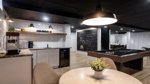A modern kitchen with white cabinets, a coffee machine, and a built-in dishwasher.