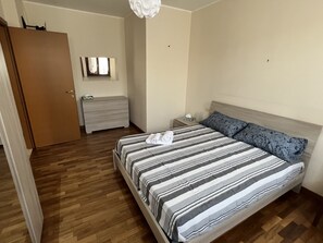 2 habitaciones, escritorio y tabla de planchar con plancha