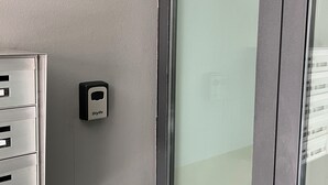Una puerta con un letrero con el número 15, un portero automático y un archivador metálico.