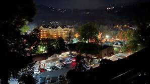 Ein Hotel mit mehreren Etagen, einem Parkplatz und umliegenden Gebäuden.