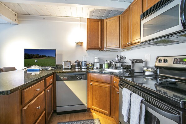 Enjoy cooking in this well-equipped kitchen with a dishwasher, microwave, and stove, plus a large island with a sink and ample counter space.