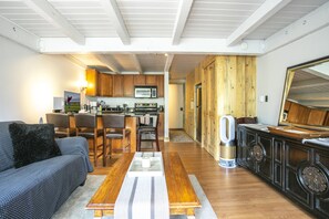 Relax in a spacious living area with a central dining table, sofa, and coffee table, perfect for dining and unwinding.