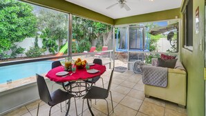 A sunlit patio with a pool, dining table, chairs, and a sofa. - Heated Pool-Family Villa 7 Min to Beach, BBQ (Deerfield Beach)