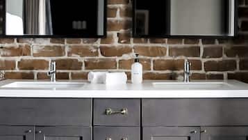 A bathroom with a double sink, dark cabinets, and a mirror above the sink.