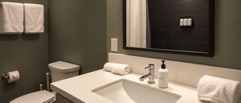 Une salle de bain moderne avec un lavabo blanc, un miroir et des toilettes.