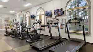 Un gimnasio con cintas de correr, elípticas y bicicletas estáticas.