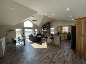 A spacious kitchen with wooden cabinets, a dining area with a table and chairs, and a large window providing a view of the outdoors.