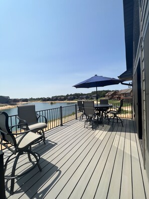 Une terrasse dotée de mobilier d’extérieur et offrant une vue sur un lac.