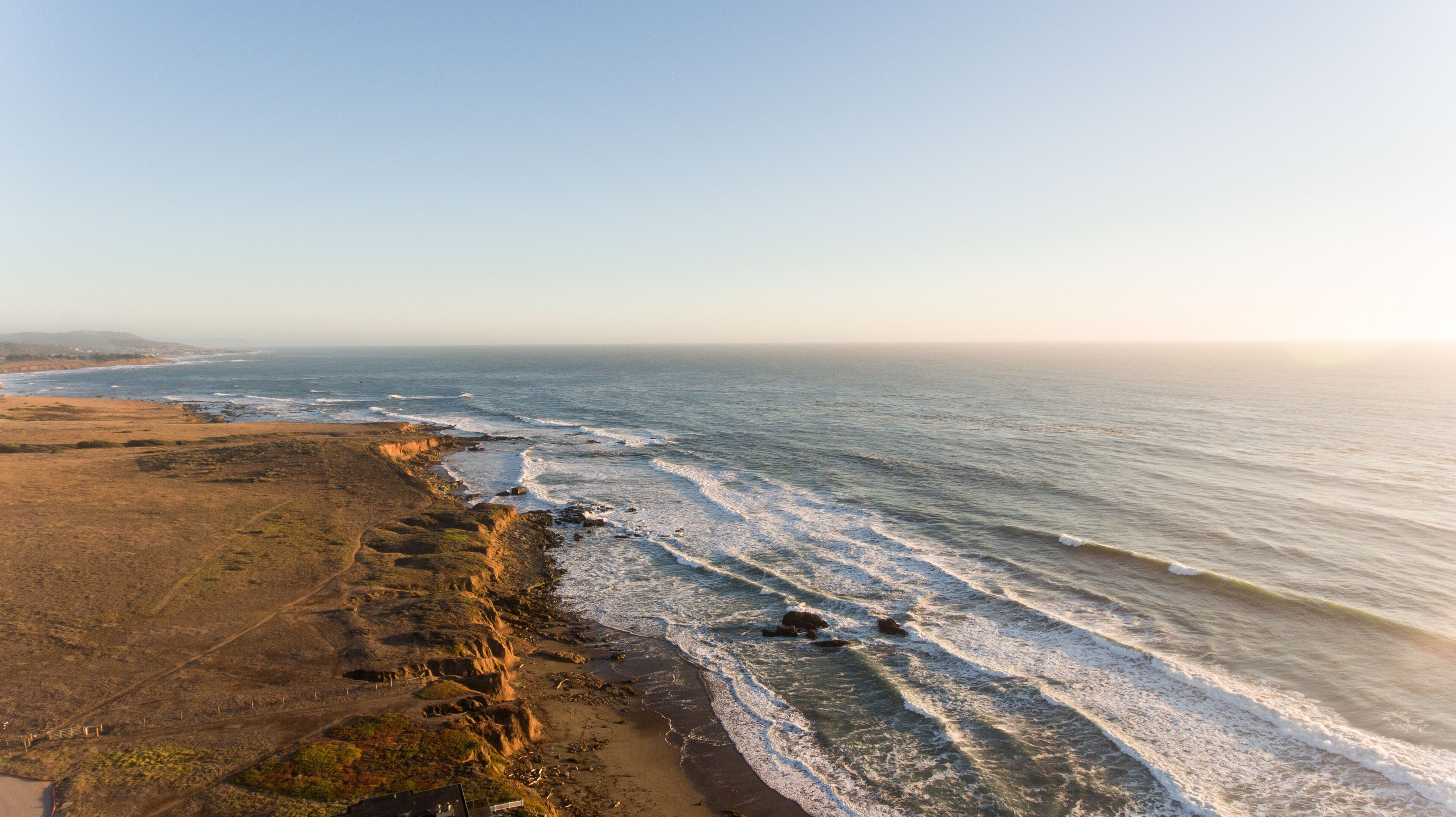 Un paysage côtier avec une plage de sable et une côte rocheuse.