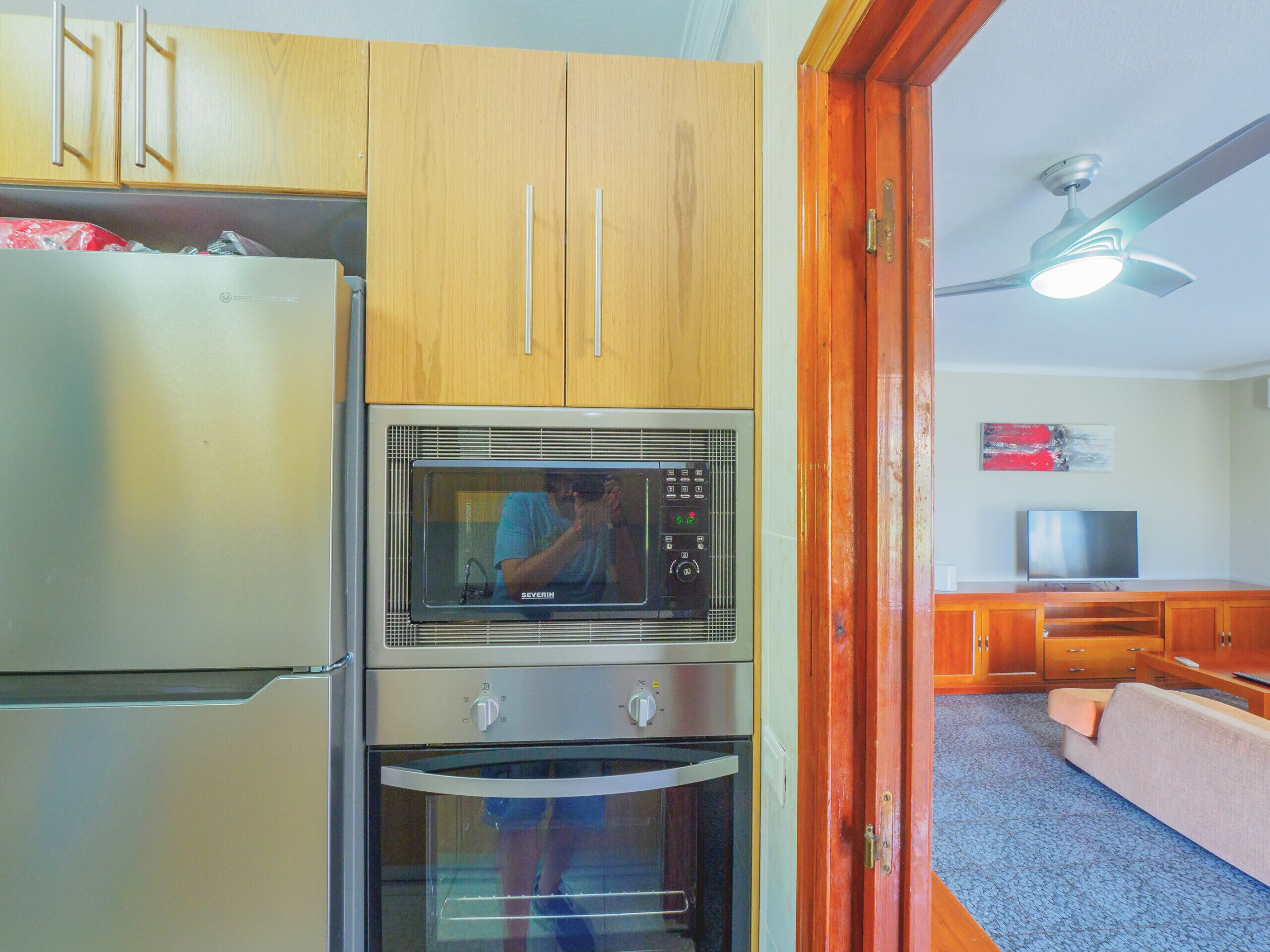 A compact kitchen with a refrigerator, microwave, and oven.