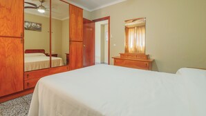 A bedroom with a bed, wooden wardrobe, a dresser, a ceiling fan, and a mirror. - Cubo's Casa Rio Grande / private pool / rural (Guaro)