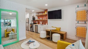 A modern hotel room with a kitchen, a dining area, and a living space. - Mello on the Beach - Shore Enuff (Holmes Beach)