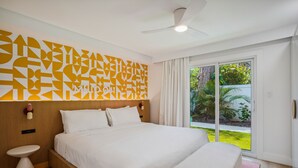 Une chambre d’hôtel moderne dotée d’un grand lit, d’une table de chevet, d’un ventilateur de plafond et offrant une vue sur l’extérieur.