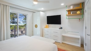 Ein modernes Schlafzimmer mit Bett, Fernseher, Schreibtisch und einem Balkon mit Blick.