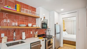 A compact kitchen with modern appliances, a built-in oven, and a refrigerator. - Mello on the Beach - Slow M'Ocean (Holmes Beach)