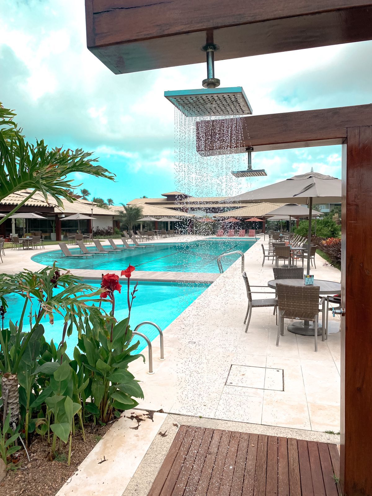A pool area with a water feature, outdoor seating, and a covered patio.