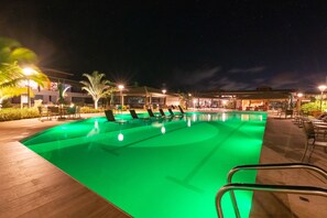 Una piscina al aire libre, sombrillas, socorrista en las instalaciones