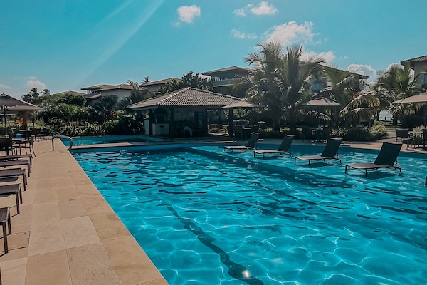 Outdoor pool, pool umbrellas, lifeguards on site