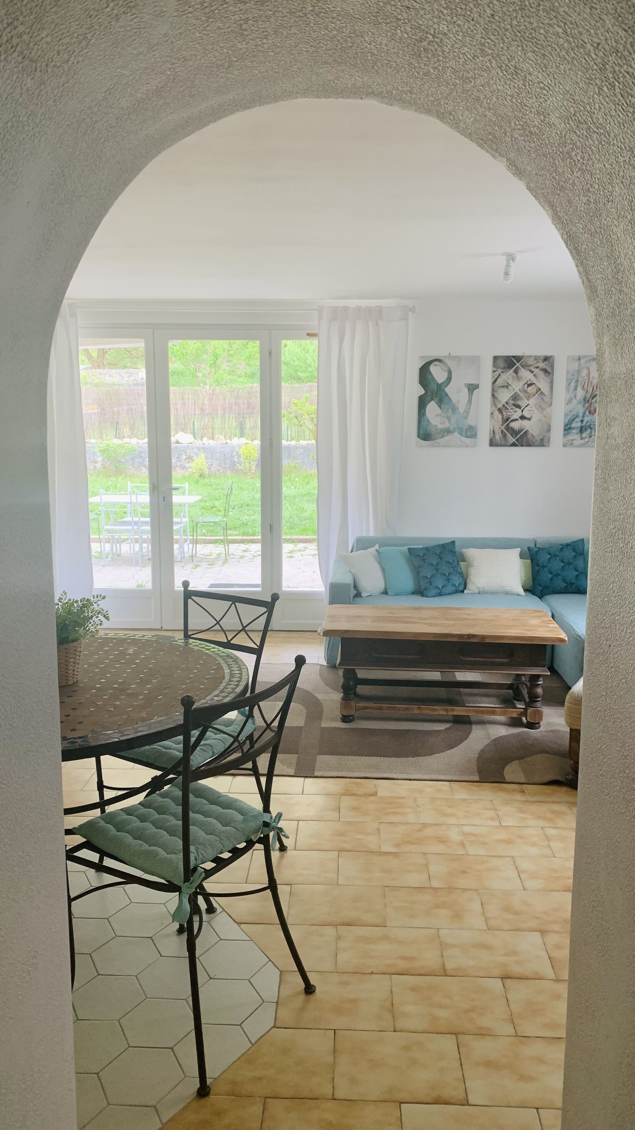 Una sala de estar acogedora con un sofá, una mesa de centro y un comedor con sillas.