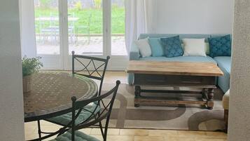 Una sala de estar acogedora con un sofá, una mesa de centro y un comedor con sillas.