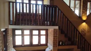 Une chambre avec un lit superposé, un escalier et une fenêtre avec des stores.