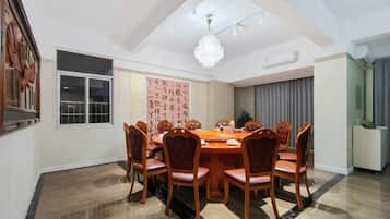 A dining room with a round table, chairs, and a chandelier.