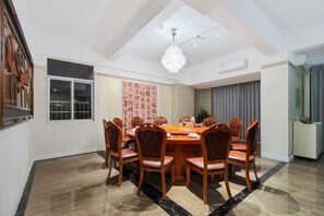 Une salle à manger avec une table ronde, des chaises et un lustre.