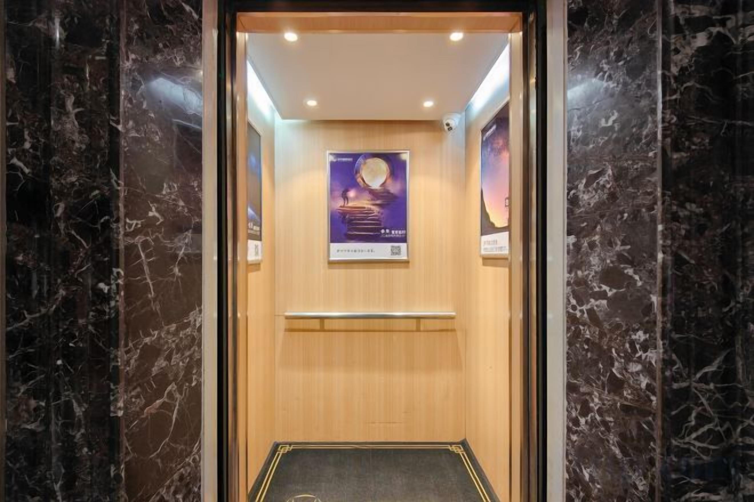 A marble-floored elevator with a wooden interior and a poster on the wall.