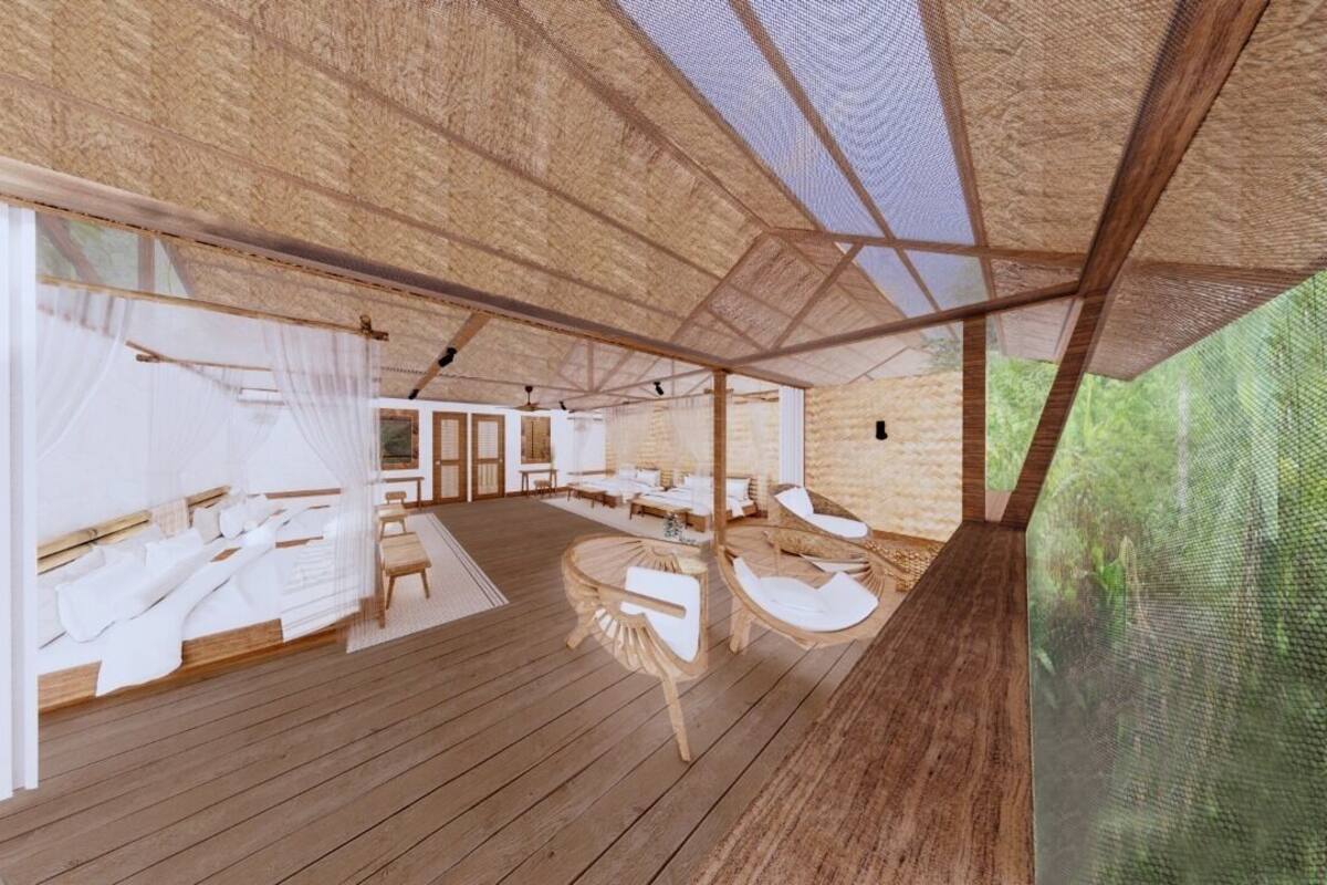 A spacious room with wooden flooring, a large bed, a seating area with chairs, and a view of greenery outside.