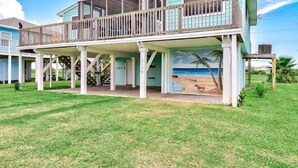 Una casa a due piani con un balcone, un portico coperto e un murale raffigurante una spiaggia.