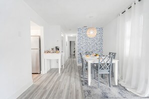 A modern kitchen with white cabinetry, a built-in oven, and a coffee machine. - 2 BD Condo - Sleeps 4 - Palm Wave Stays (Coconut Creek)