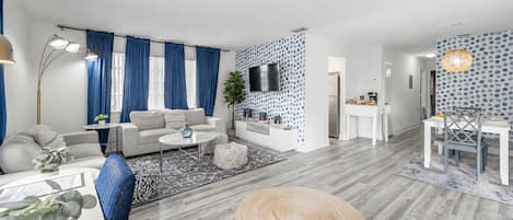 A modern living room with a sofa, coffee table, and a TV mounted on the wall.