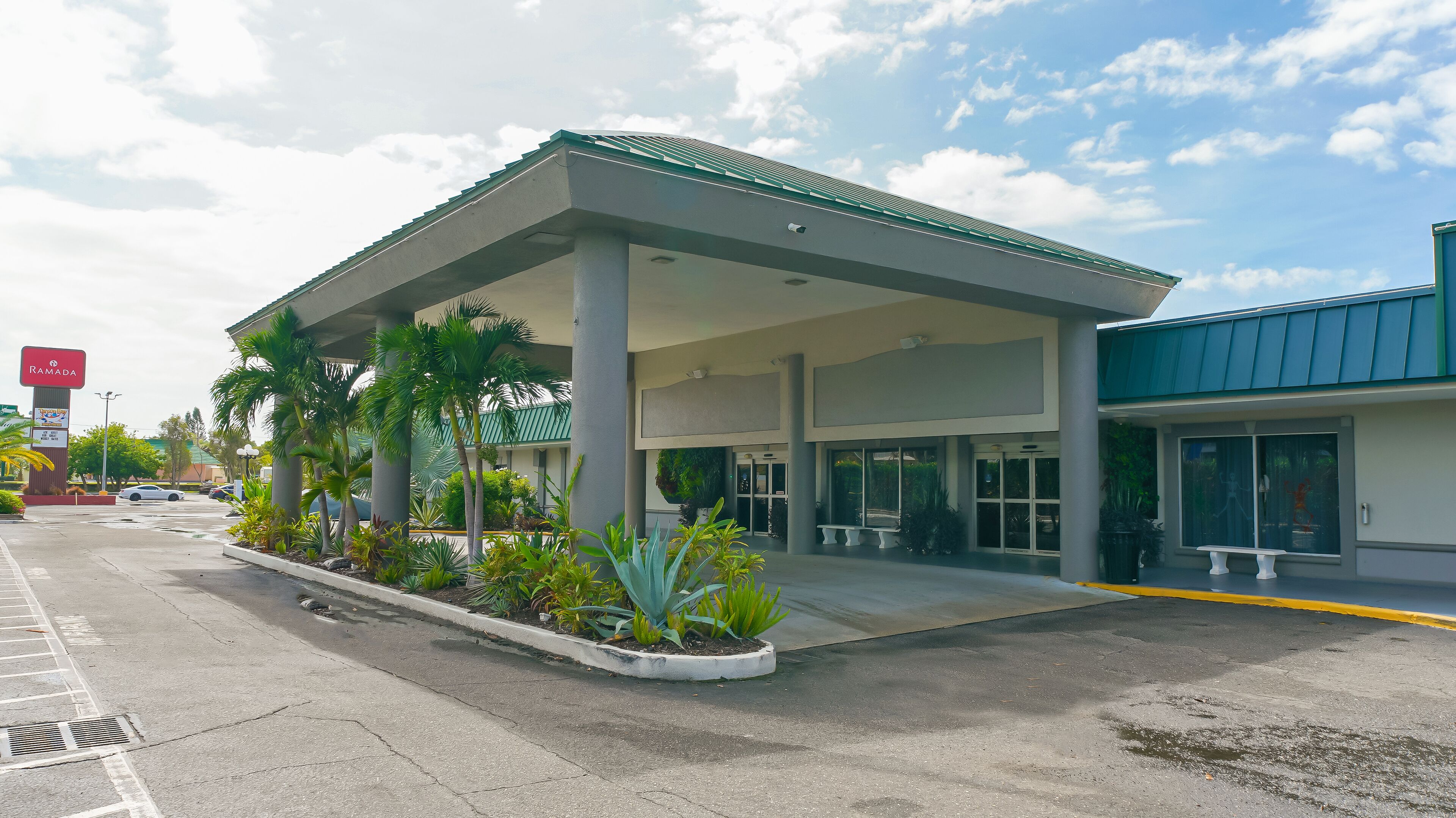 Une station-service dotée d’un auvent, de palmiers et d’une enseigne Ramada.