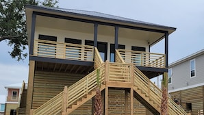 A two-story building with a wooden staircase leading to a balcony. - Family-Friendly! (Gulfport)