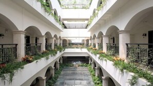 A courtyard with a central water feature, surrounded by arches and greenery. - Zhonghui Hotel (Lingchuan)